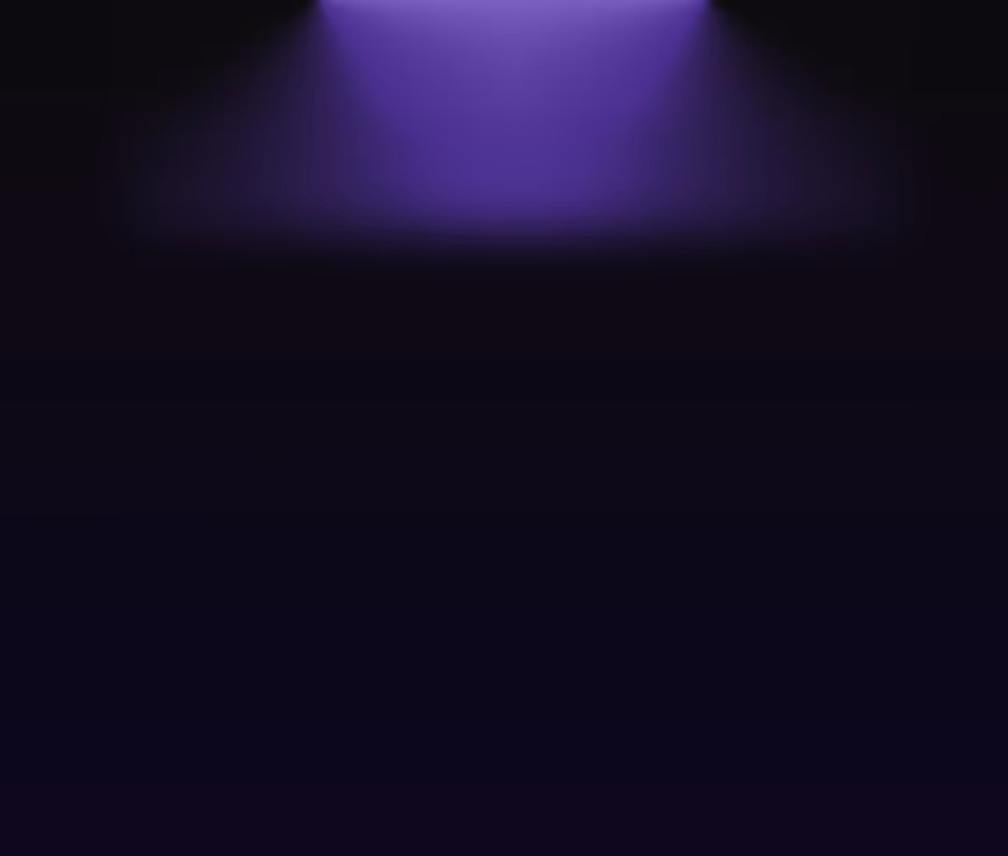 Purple spotlight shining down on a dark stage with a black background.