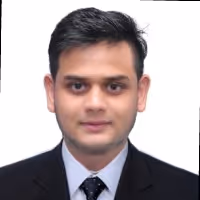 Portrait of a man with short black hair wearing a black suit and tie against a white background.