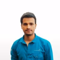 Man with short dark hair wearing a teal blue collared shirt against a plain white background.