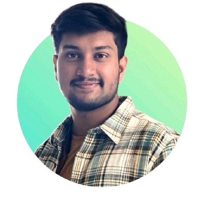 Young man with short dark hair and beard wearing a plaid shirt, smiling against a green circular background.