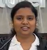 Portrait of a young woman with dark hair, wearing a white shirt and dark jacket, smiling slightly.
